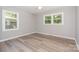 Inviting bedroom featuring two bright windows that illuminate grey walls and durable light wood-look floors at 1138 Laurel St, Salisbury, NC 28144