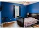 Cozy bedroom featuring warm lighting, dark blue walls, wood-look floors, and a comfortable bed at 118 Cypress Acres Ln, Statesville, NC 28625