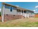 Charming home exterior with brick foundation, vinyl siding, and inviting covered front porch with white railing at 118 Cypress Acres Ln, Statesville, NC 28625