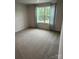 Bedroom featuring neutral walls, carpet flooring, and a window with natural light at 1411 Cottage Green Dr # 218, Monroe, NC 28112