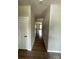 This hallway has wooden floor, white walls, doors and ceiling lights at 1411 Cottage Green Dr # 218, Monroe, NC 28112