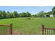 Expansive green back yard with mature trees, shed, and partial view from wood deck at 142 Family Ln, Mount Holly, NC 28120