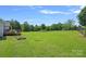 Picture of the spacious back yard, including a deck and mature trees at 142 Family Ln, Mount Holly, NC 28120