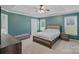 Cozy bedroom featuring tray ceiling, ceiling fan, neutral carpet, and ensuite at 142 Family Ln, Mount Holly, NC 28120