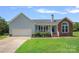 Charming single-Gathering home featuring a two-car garage, brick accents, and a well-maintained front lawn at 142 Family Ln, Mount Holly, NC 28120