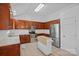 Well-lit kitchen featuring ample wood cabinetry, stainless steel appliances, and a portable kitchen island at 142 Family Ln, Mount Holly, NC 28120