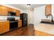 A kitchen equipped with modern stainless steel appliances, wood cabinets, and vinyl flooring at 1432 Matthew Allen Cir, Kannapolis, NC 28081