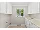 Bright laundry room with sink, window view, and ample storage space at 1505 N Cansler St, Kings Mountain, NC 28086