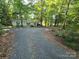 Gravel driveway leading to a single story home secluded in the woods with covered parking area at 16711 Indian Mound Rd, Albemarle, NC 28001