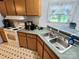 A well-lit kitchen features a double sink, light countertops, and light wooden cabinets, adding charm to the home at 16711 Indian Mound Rd, Albemarle, NC 28001