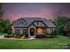 Charming stone and siding home with well-manicured landscaping and a welcoming front entrance at twilight at 2009 Freeport Dr, Indian Trail, NC 28079