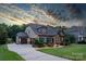 Beautiful home exterior featuring a three-car garage, stone accents, and manicured landscaping at 2009 Freeport Dr, Indian Trail, NC 28079