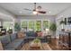 Bright living room with a large sectional couch, hardwood floors, and many windows at 2009 Freeport Dr, Indian Trail, NC 28079