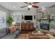 Inviting living room featuring a stone fireplace, ceiling fan, and view into the main bedroom at 2009 Freeport Dr, Indian Trail, NC 28079