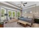 Bright main bedroom boasts a tufted headboard, sitting area, and large windows with wooded views at 2009 Freeport Dr, Indian Trail, NC 28079