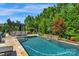 Backyard swimming pool area featuring a rock waterfall and a pergola with dining, set amongst green foliage at 2009 Freeport Dr, Indian Trail, NC 28079