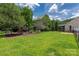 Expansive backyard with lush lawn, mature trees, and a wooden playset for outdoor enjoyment at 205 Honey Moss Ln, Salisbury, NC 28146
