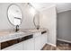 Bathroom featuring double vanities with granite countertops and framed mirrors at 205 Honey Moss Ln, Salisbury, NC 28146