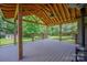 A spacious covered deck with wood floors, ceiling fan, and railing, perfect for outdoor relaxation at 205 Honey Moss Ln, Salisbury, NC 28146