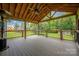 Covered deck with ceiling fan, wood floors and railing overlooking the backyard at 205 Honey Moss Ln, Salisbury, NC 28146