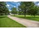 Long driveway leading to a home surrounded by mature trees and a lush green lawn at 205 Honey Moss Ln, Salisbury, NC 28146