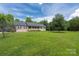 Beautiful brick home showcasing a covered porch with white railings and mature trees at 205 Honey Moss Ln, Salisbury, NC 28146
