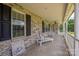 Charming front porch featuring white lounge furniture, brick walls, and dark shutters at 205 Honey Moss Ln, Salisbury, NC 28146