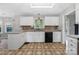 Traditional kitchen with white cabinets, tile floors, and black appliances at 205 Honey Moss Ln, Salisbury, NC 28146
