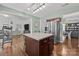 Open-concept kitchen with a center island, stainless steel refrigerator, and seamless flow into the adjacent living areas at 2301 Amesbury Ct, Albemarle, NC 28001