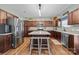 Spacious kitchen featuring dark wood cabinets, stainless steel appliances, and a center island with seating at 2301 Amesbury Ct, Albemarle, NC 28001