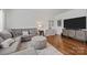 A cozy living room features a gray sofa, ottoman, wood floors, and a modern entertainment center at 2301 Amesbury Ct, Albemarle, NC 28001