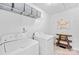 Functional laundry room is equipped with washer, dryer, shelving, and a stylish wooden table at 2512 Andes Dr, Statesville, NC 28625