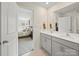 Bright bathroom featuring a double sink vanity with view to the bedroom, tiled floors, and modern fixtures at 404 Saddlebred Ln, Locust, NC 28097