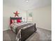Nicely decorated bedroom features a bed and a side table with a lamp and a star at 404 Saddlebred Ln, Locust, NC 28097
