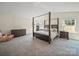 Bedroom with a large four-poster bed, complemented by matching nightstands and dresser, and large windows at 404 Saddlebred Ln, Locust, NC 28097