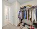 Walk-in closet filled with clothing and shoes, showcasing ample storage space, and carpet at 404 Saddlebred Ln, Locust, NC 28097