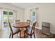 Charming dining area with wood table, chairs, sliding door to the backyard, and stainless steel mini-refrigerator at 404 Saddlebred Ln, Locust, NC 28097
