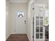 Bright foyer featuring wood floors, white trim, and a glass paneled office doorway at 404 Saddlebred Ln, Locust, NC 28097