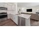 Stylish kitchen featuring stainless steel appliances, a large sink, and an open layout to the living space at 404 Saddlebred Ln, Locust, NC 28097