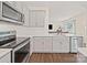 Bright kitchen with stainless steel appliances, white cabinets, and an open layout to the living space at 404 Saddlebred Ln, Locust, NC 28097
