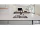 Close up of the kitchen sink, white quartz countertop, and black plumbing fixture at 404 Saddlebred Ln, Locust, NC 28097