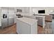 Modern kitchen boasts stainless steel appliances, a center island, and open layout to the living area at 404 Saddlebred Ln, Locust, NC 28097
