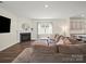Inviting living room features a fireplace, neutral palette, and an adjacent kitchen at 404 Saddlebred Ln, Locust, NC 28097