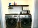 Bright laundry room with modern front load washer and dryer, and extra shelving for storage at 4205 Springhaven Dr, Charlotte, NC 28269