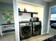 Well-organized laundry area with modern washer and dryer, shelving, and decor at 4205 Springhaven Dr, Charlotte, NC 28269