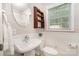 Cozy bathroom with a pedestal sink, decorative shelving, and a window for natural light at 4919 Rehobeth Rd, Waxhaw, NC 28173