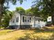 Exterior shot of a charming home featuring black shutters, white siding and landscaped front yard at 608 E 11Th St, Newton, NC 28658