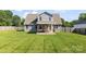 Spacious backyard showcasing a covered patio, a large lawn, and wooden fencing, ideal for relaxation and recreation at 6401 Morehead Rd, Harrisburg, NC 28075
