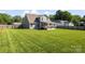 Well-maintained backyard with a spacious deck, lush green lawn, and privacy fencing for outdoor living at 6401 Morehead Rd, Harrisburg, NC 28075