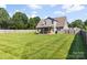 Expansive backyard featuring a covered patio, lush lawn, and privacy fencing, perfect for outdoor enjoyment at 6401 Morehead Rd, Harrisburg, NC 28075